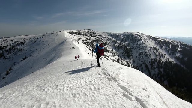 a group of tourists travels through the snow-capped mountains