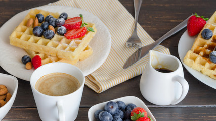 Belgian waffle decorated  with strawberries,  blueberries and almond on wooden table for perfect  breakfast at Sunday. Homemade dessert background. Relax moments concept and lifestyle image