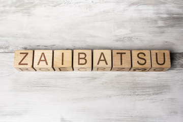 word ZAIBATSU made from wooden cubes on wooden background