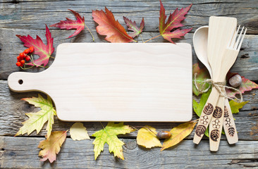 Autumn leaves and empty cutting board food fall background concept
