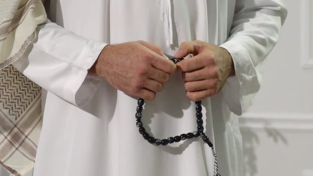 Middle easter religious man standing with subha in his hands.