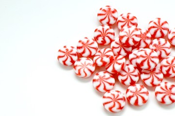 Red and white peppermints on a white background