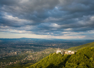 Fototapeta premium Aerial photograph of Sofia TV tower, Bulgaria - amazing scenery under the golden light of the setting sun with dark and moody skies