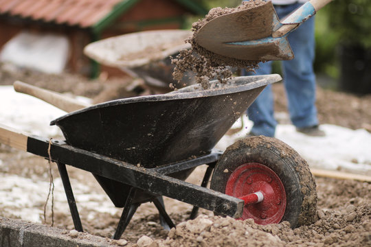 gravel filled in with shovel into wheelbarrow