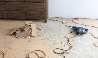 Construction concept - Jackhammer, removing chipboard from the floor