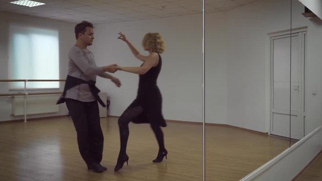 Man and a woman are dancing in the studio