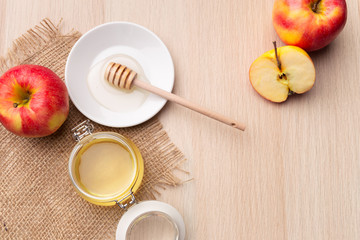 Jewish holiday Rosh Hashanah background with honey and apples on wooden table.