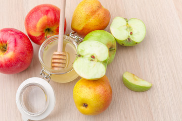 Jewish holiday Rosh Hashanah background with honey and apples on wooden table.
