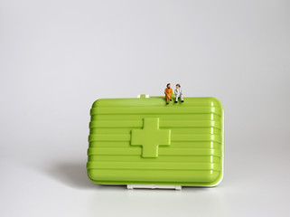 Obraz premium A miniature old couple sitting on a green medicine chest.