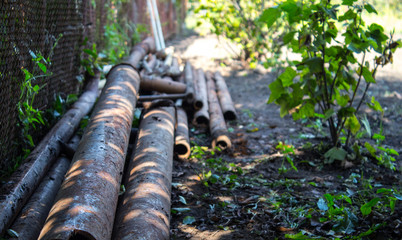 Fototapeta na wymiar a old rusty metal pipes on the backyard