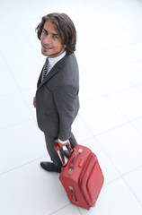 smiling businesswoman with travel suitcase