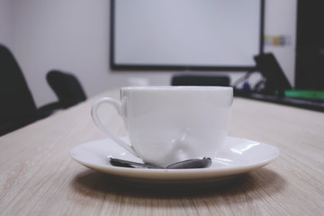 coffee cup on wooden table in meeting room