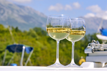Pair of wineglasses against the yacht