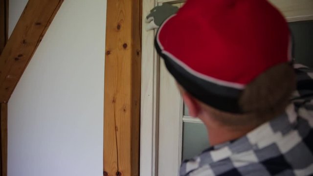 Home improvement. A handyman installing a closing wood slab for the door