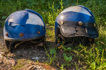 Two old broken motorcycle helmet on the ground