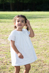 beauty cute child girl outdoor with white pretty dress