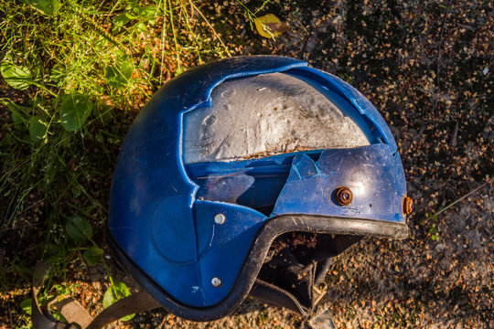 One Old Broken Motorcycle Helmet On The Ground