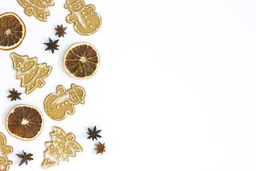 Gingerbreads, anise and dry oranges on a white background.Christmas composition