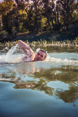 The young man swimming in the river