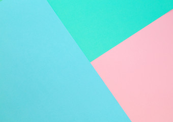 Triangle. Blue, pink and light green color paper background. Image with space for text.