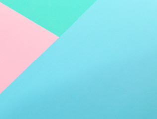 Triangle. Blue, pink and light green color paper background. Image with space for text.