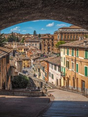 Charming old street of medieval towns of Italy-Perugia in Umbria, gloomy and deserted with huge arches, stairs and bridge - obrazy, fototapety, plakaty