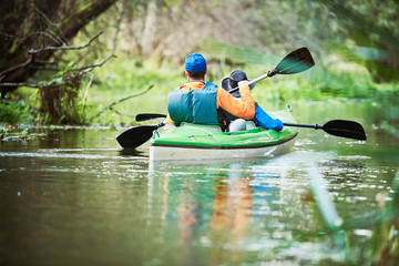 Kayaking on river in forest. Family on canoe. Active recreation and vacation