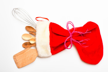 Christmas gift concept. Kitchen accessories or kit of kitchenware packed in big red sock, white...