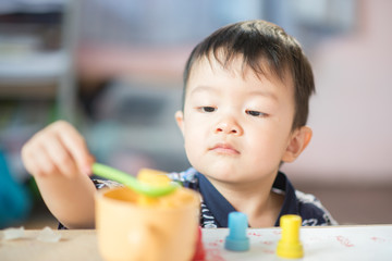 Little boy eating cut mango  friut at home