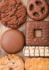Oat and chocolate cookies selection on wooden board on stone kitchen table background. Macro close up