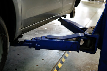 car on lift in auto service repair garage