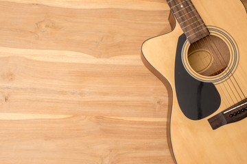 acoustic guitar on a wooden desk.