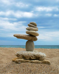 Stones balance on a background of cloudy sky and sea