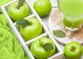 Glass of fresh organic apple juice with granny smith green apples in box on wooden background - Powered by Adobe