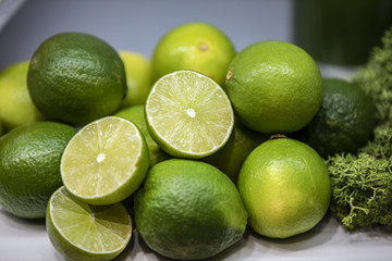 Full and cut lemons in a basket alongside with broccoli