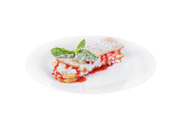 Dessert with cream, whipped cream, berry, strawberry syrup and biscuits, puff pastry, mint leaf, powdered sugar, on a plate, isolated white, side view. For the menu of a cafe, restaurant, bar