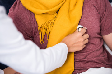 cropped shot of female doctor using stethoscope to listen to patients breath