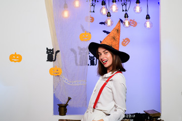 Halloween Witch with in magic hat. Beautiful young surprised woman in witches hat and costume....