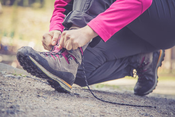 Junge Frau bindet ihre Wanderschuhe, Wanderung