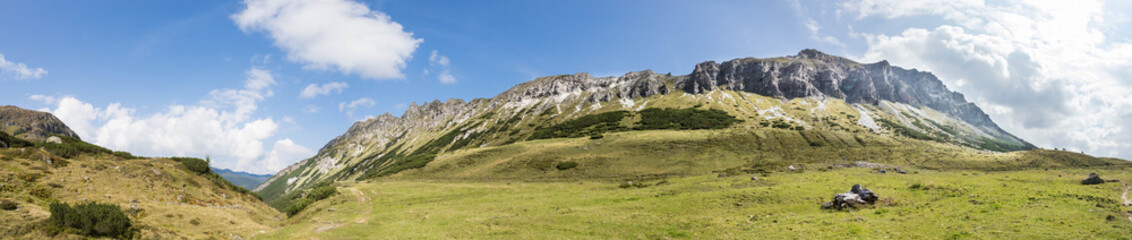 Fototapeta na wymiar Almlandschaft in Salzburg, Felsen, Berggipfel und blauer Himmel, Panorama