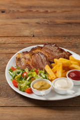 Grilled pork neck served with French fries and salad.