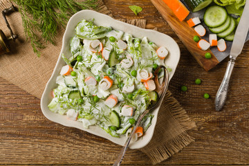 Crab sticks salad with peas, cucumber and mayonnaise.