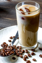 coffee with ice in glass on wooden background