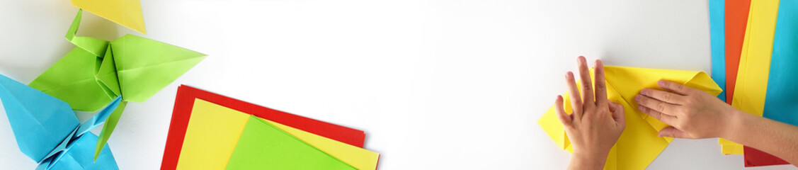 Web banner, origami kids.  Color cranes of origami from paper on a white background
