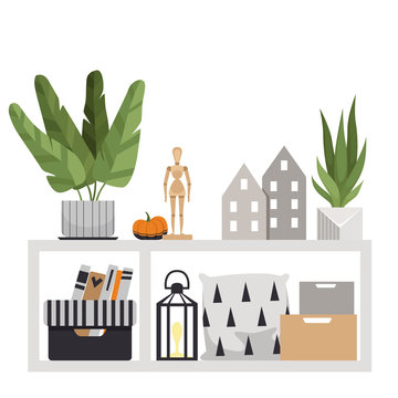 Floor table with interior items. A plant, pillows, boxes, a wooden figurine, a pumpkin, small houses and a flashlight. Interior composition in Scandinavian style