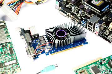 Graphics card with computer parts on white background. Selective focus
