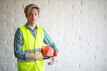 Asian man in protective helmet and construction waistcoat