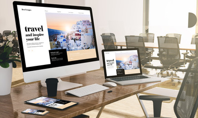 computer, laptop, tablet, and phone with responsive travel blog website  at office mockup