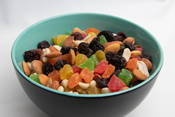 dried fruits and nuts in a green plate on a white background, isolate