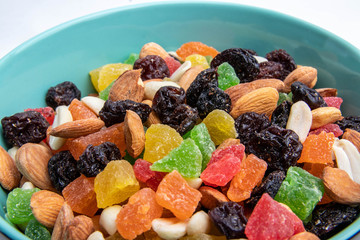dried fruits and nuts in a green plate on a white background, isolate